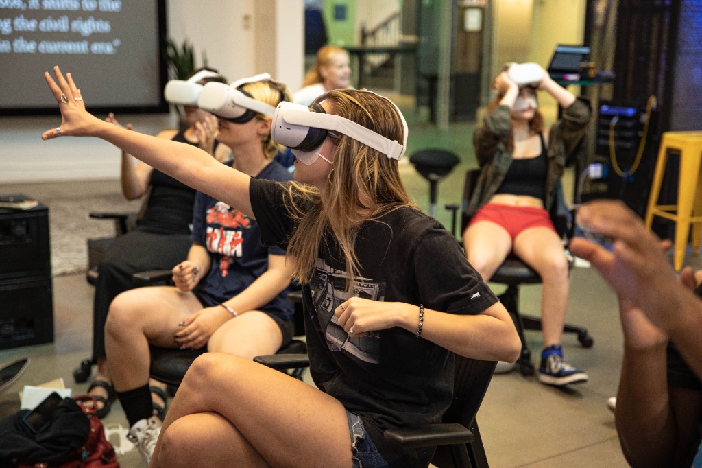 Workshop participant reaching forward while immersed in a VR experience